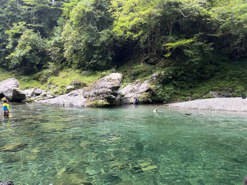 みたらい渓谷周辺の澄んだ川で川遊びをする人たち
